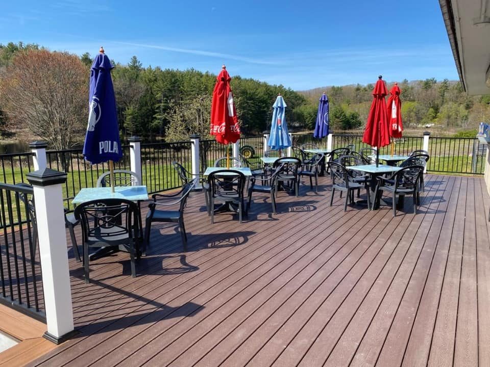 Outdoor deck with tables and umbrellas at Big Deal in Spofford, NH